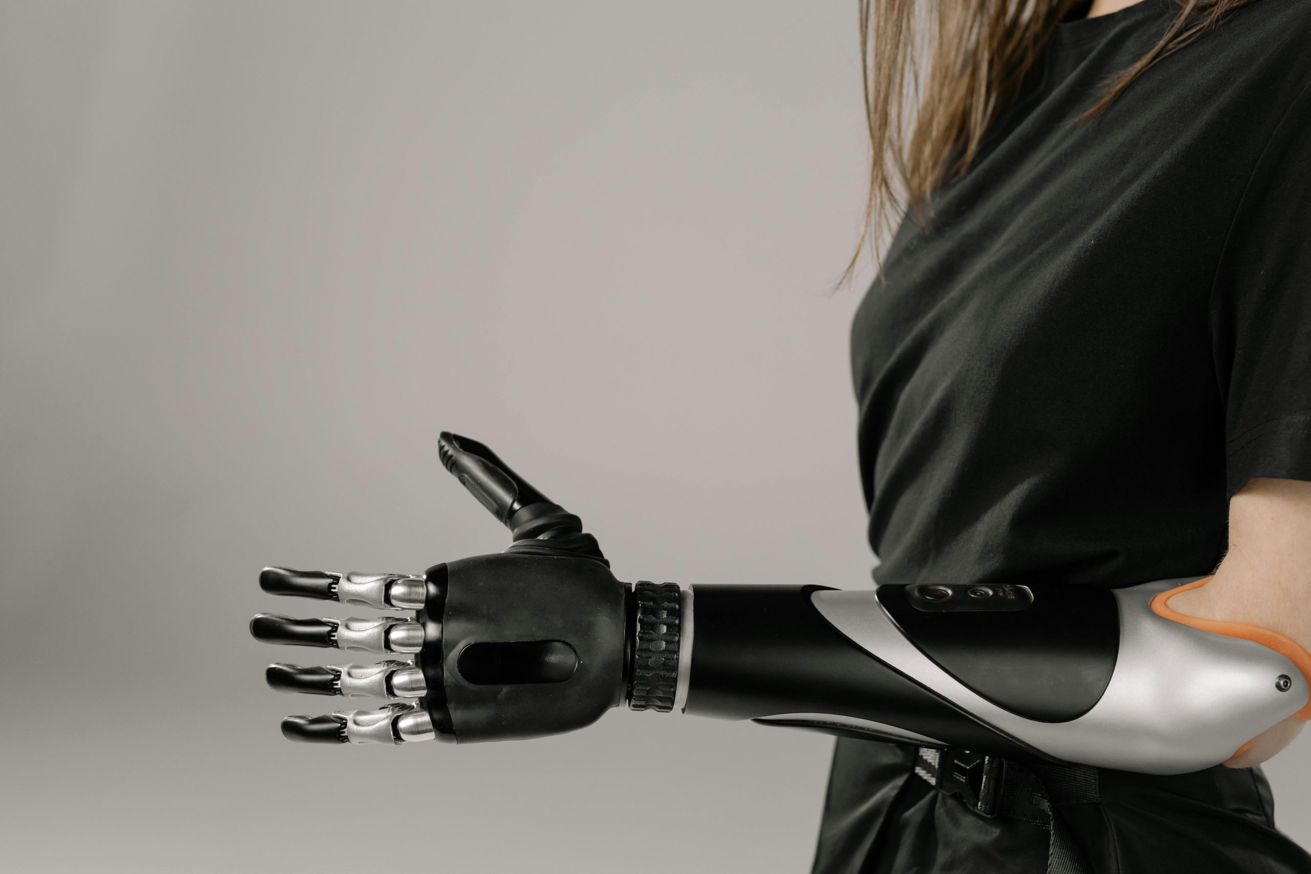 Close-up of a woman wearing a sleek, modern prosthetic arm. Studio shot emphasizes technology and innovation.